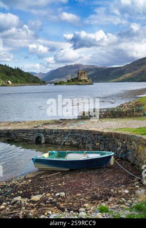 Guardando verso sud lungo Loch Duich fino al castello di Eilean Donan, accanto alla strada principale A87 per Skye, a nord di Morvich. Barca e attrezzatura da pesca sullo scalo. Rinomato, Foto Stock