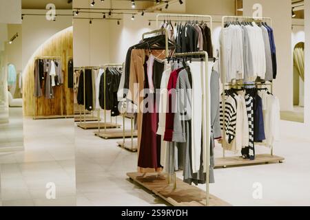 Ampia scelta di lussuose e ricche boutique con abiti firmati da donna appesi su grucce Foto Stock