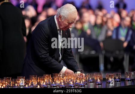 Re Carlo III posa una candela durante le commemorazioni ad Auschwitz-Birkenau in Polonia per celebrare i 80 anni dalla liberazione del campo di concentramento il 27 gennaio 1945. Data foto: Lunedì 27 gennaio 2025. Foto Stock