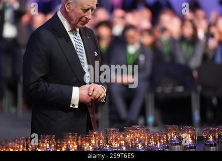 Re Carlo III posa una candela durante le commemorazioni ad Auschwitz-Birkenau in Polonia per celebrare i 80 anni dalla liberazione del campo di concentramento il 27 gennaio 1945. Data foto: Lunedì 27 gennaio 2025. Foto Stock