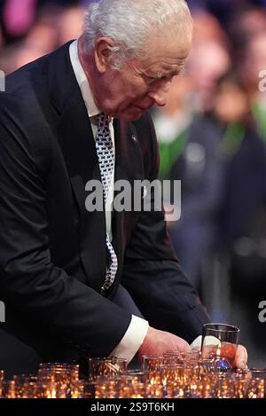 Re Carlo III posa una candela durante le commemorazioni ad Auschwitz-Birkenau in Polonia per celebrare i 80 anni dalla liberazione del campo di concentramento il 27 gennaio 1945. Data foto: Lunedì 27 gennaio 2025. Foto Stock