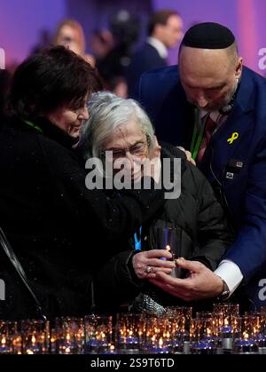 Una sopravvissuta di Auschwitz viene confortata mentre posa una candela durante le commemorazioni ad Auschwitz-Birkenau in Polonia per celebrare i 80 anni dalla liberazione del campo di concentramento il 27 gennaio 1945. Data foto: Lunedì 27 gennaio 2025. Foto Stock