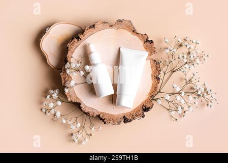 Prodotti cosmetici e fiori di gypsophila su legno e sfondo beige, vista dall'alto. Eco-compatibile bellezza biologica, mock-up per la cura della pelle naturale. Foto Stock