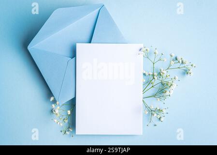 Mockup per biglietti di auguri o inviti, bianco vuoto con decorazioni floreali su sfondo bue, spazio per copie. Elegante mockup creativo con gypsophila bianca Foto Stock