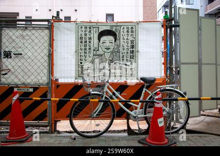 Poster in tessuto per la società edile Miyazawa di Akabane sulla recinzione di un cantiere ad Akabane, Tokyo, Giappone, con una bicicletta parcheggiata. Foto Stock