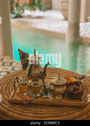 Invitante fotografia del tradizionale tè marocchino, servito in teiere e bicchieri dal design sofisticato. Foto Stock