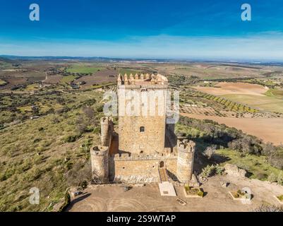 Vista aerea del castello di Nogales in Spagna con torre omaggio, merlature e 4 torri circolari sulla cima di una collina Foto Stock