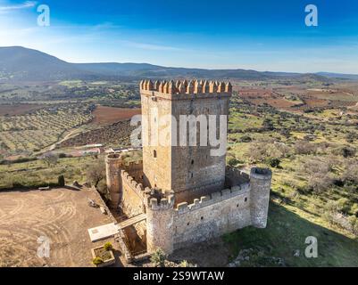 Vista aerea del castello di Nogales in Spagna con torre omaggio, merlature e 4 torri circolari sulla cima di una collina Foto Stock
