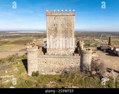Vista aerea del castello di Nogales in Spagna con torre omaggio, merlature e 4 torri circolari sulla cima di una collina Foto Stock