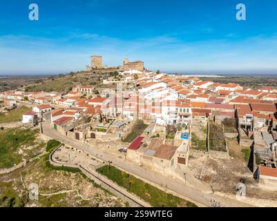 Vista aerea di Nogales nell'Estremadura, in Spagna, tipico villaggio collinare spagnolo con case bianche, chiesa e castello Foto Stock