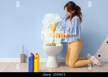 Giovane donna che pulisce la ciotola sporca del bagno in bagno Foto Stock