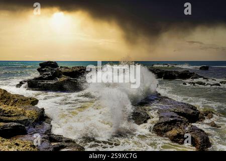 Tempesta le nuvole al tramonto sulle rocce vulcaniche di Canggu, Bali, Indonesia Foto Stock