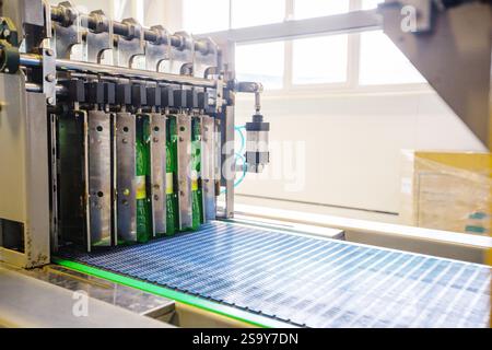 Automazione nel processo di confezionamento in esposizione con le bottiglie in movimento attraverso un trasportatore in un moderno stabilimento industriale Foto Stock
