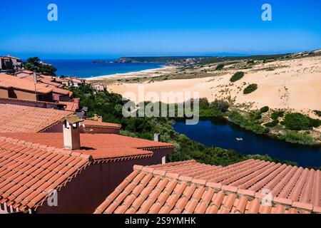 Vista aerea sui tetti delle case nel piccolo villaggio di Torre dei Corsari, sulla spiaggia di Arenas S'acqua e S'Ollastu e sulle grandi dune di sabbia. Foto Stock