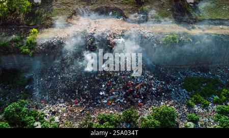 Bruciare una discarica illegale a Bukit, Bali. vista aerea. Inquinamento da rifiuti di plastica nelle discariche Foto Stock