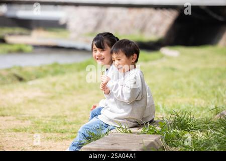 Sorridente bambino seduto su una panchina sorriso Foto Stock