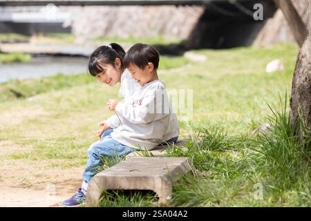 Sorridente bambino seduto su una panchina sorriso Foto Stock