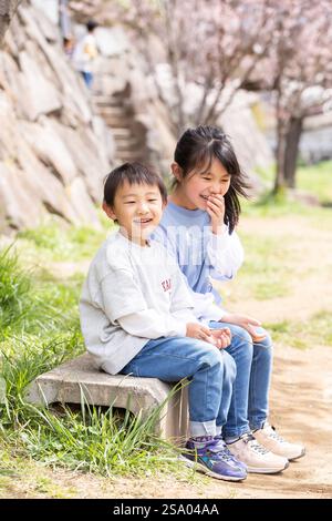 Sorridente bambino seduto su una panchina sorriso Foto Stock