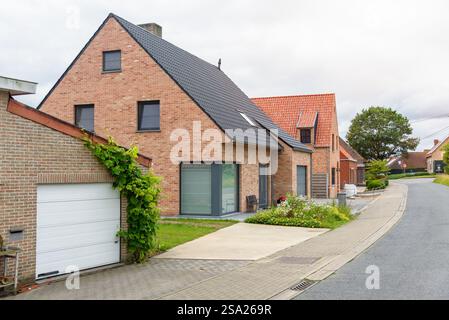Moderne case in mattoni lungo una strada in uno sviluppo abitativo nella campagna belga in una tosse giornata estiva Foto Stock