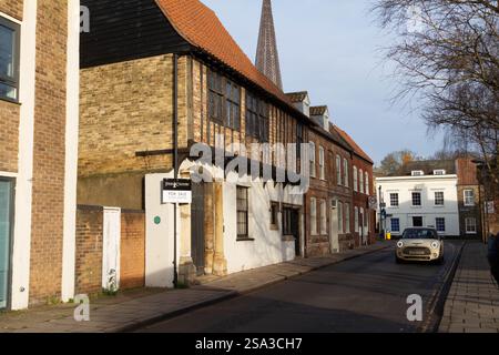 Un mini viaggio bianco lungo St Nicholas Street passando davanti a Woolmarket House e ad altri edifici storici a Kings Lynn Foto Stock