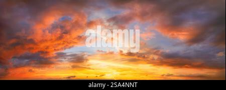Cielo luminoso al tramonto con nuvole maestose di colore arancione illuminate. Una vivace foto panoramica di nuvole. Foto Stock