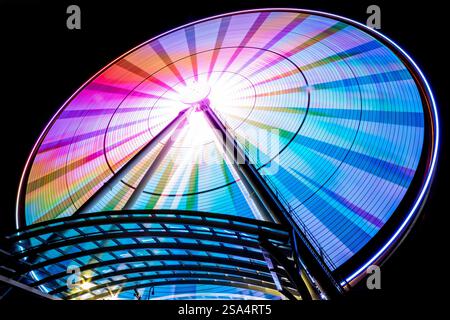 Un'artistica vista fisheye grandangolare della grande ruota di Seattle che brilla vibrante di notte, mostrando i suoi colori sbalorditivi e le linee dinamiche. Foto Stock