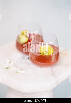 Rinfrescanti bevande floreali ornate da delicati fiori su una superficie di marmo durante un pomeriggio di sole Foto Stock