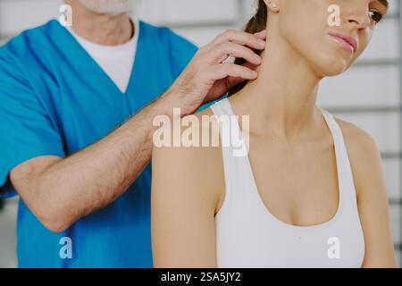 Primo piano medio di una donna turbata che soffre di dolore nella colonna cervicale mentre un medico professionista esamina questa zona Foto Stock