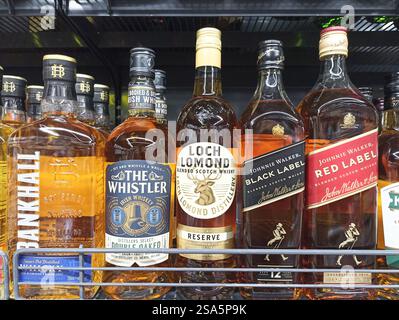 Bottiglie di whisky assortite sullo scaffale del negozio di liquori. Foto Stock