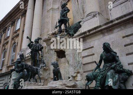 Primo piano delle statue di bronzo di una scena di caccia sulla Fontana di Mattia presso la corte del castello del Palazzo reale di Budapest, in Ungheria Foto Stock