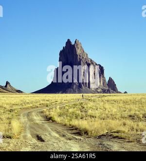 Una strada sterrata a due piste che attraversa l'arido deserto della riserva indiana Navajo vicino a Ship Rock, New Mexico. Foto Stock