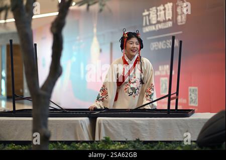 New York, Stati Uniti. 28 gennaio 2025. Una giovane donna parla con i passanti indossando abiti decorativi e acconciature per celebrare l'anno del serpente per le prossime festività del capodanno lunare cinese, nella sezione Chinatown di Flushing, Queens, NY, 28 gennaio 2025. (Foto di Anthony Behar/Sipa USA) credito: SIPA USA/Alamy Live News Foto Stock