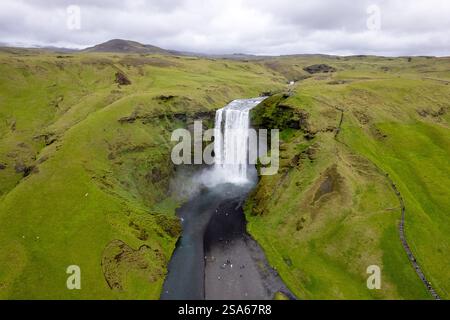 Cascata panoramica cascata Skogafoss in Islanda tra lussureggianti paesaggi islandesi verdi in una giornata ricoperta nell'area del cerchio d'Oro Foto Stock