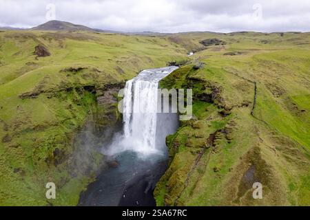 Cascata panoramica cascata Skogafoss in Islanda tra lussureggianti paesaggi islandesi verdi in una giornata ricoperta nell'area del cerchio d'Oro Foto Stock