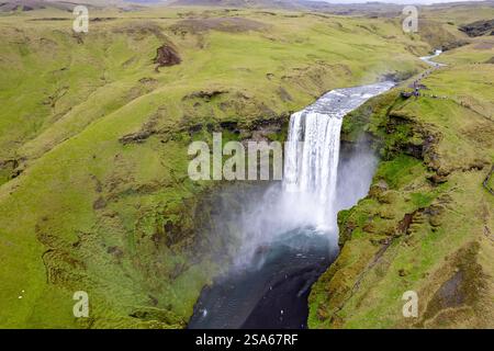 Cascata panoramica cascata Skogafoss in Islanda tra lussureggianti paesaggi islandesi verdi in una giornata ricoperta nell'area del cerchio d'Oro Foto Stock