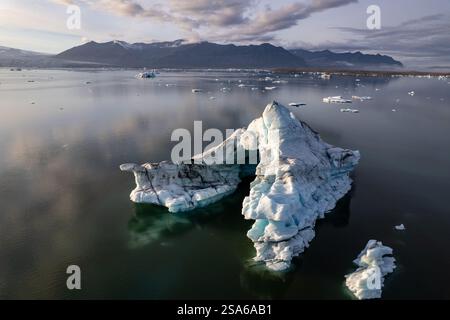 Veduta aerea con droni degli iceberg che galleggiano sulla laguna del ghiacciaio Jokulsarlon in Islanda sopra una montagna incredibile Foto Stock
