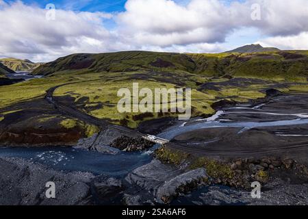 Vista aerea con droni esplorando il paesaggio della valle del fiume con un'auto bianca solitaria 4x4 su una strada sterrata per il campeggio Thakgil (Pakgil) vicino a Vik in Islanda Foto Stock