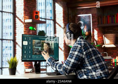 Telelavoratore in ufficio domestico che utilizza un programma per convertire messaggi di testo in uscita video. Creazione di contenuti in remoto che utilizza il testo per creare modelli generativi per la tecnologia di intelligenza artificiale sul computer Foto Stock