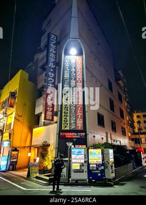 Una strada tipica di notte ad Akabane, Tokyo, Giappone, con distributori automatici di bevande. Foto Stock