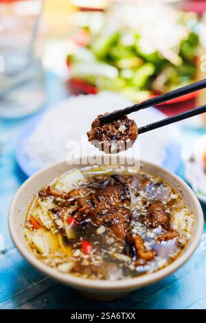 Bun Cha tradizionale piatto vietnamita di maiale alla griglia e spaghetti di riso servito con erbe fresche e salsa per immersione Foto Stock