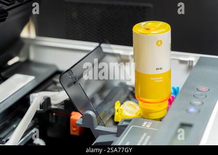 Le stampanti a getto d'inchiostro piene. Stampante a getto d'inchiostro. ricaricare la stampante con serbatoio d'inchiostro in ufficio. Chiudere la cartuccia della stampante a getto d'inchiostro CMYK di colore giallo e riparare il problema Foto Stock