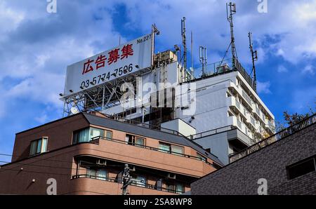 Un cartellone inutilizzato in cima ad un alto edificio di appartamenti nella parte ovest di Tokyo, che dichiara in giapponese che il cartellone è disponibile per la pubblicità Foto Stock