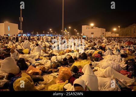 Mecca, Arabia Saudita - 15 giugno 2024: Pellegrini provenienti da vari paesi a Muzdalifah, un'area aperta situata tra la Mecca e Mina, Arabia Saudita. Foto Stock