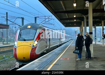 Passeggeri in attesa nella magnificenza della stazione ferroviaria di York, North Yorkshire, North East England, Regno Unito Foto Stock
