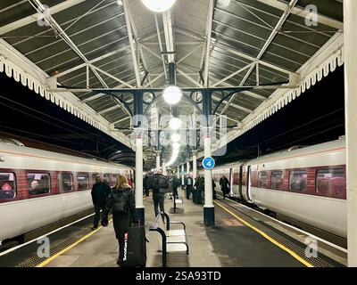 Passeggeri in attesa nella magnificenza della stazione ferroviaria di York, North Yorkshire, North East England, Regno Unito Foto Stock