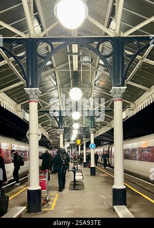 Passeggeri in attesa nella magnificenza della stazione ferroviaria di York, North Yorkshire, North East England, Regno Unito Foto Stock