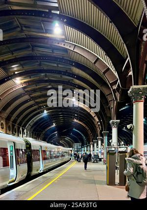 Passeggeri in attesa nella magnificenza della stazione ferroviaria di York, North Yorkshire, North East England, Regno Unito Foto Stock