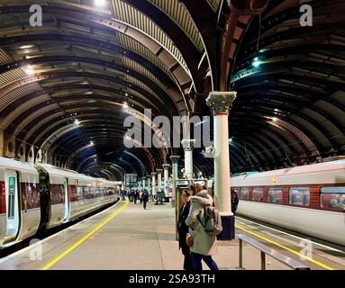 Passeggeri in attesa nella magnificenza della stazione ferroviaria di York, North Yorkshire, North East England, Regno Unito Foto Stock