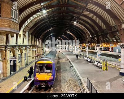 Passeggeri in attesa nella magnificenza della stazione ferroviaria di York, North Yorkshire, North East England, Regno Unito Foto Stock