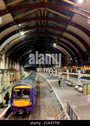 Passeggeri in attesa nella magnificenza della stazione ferroviaria di York, North Yorkshire, North East England, Regno Unito Foto Stock